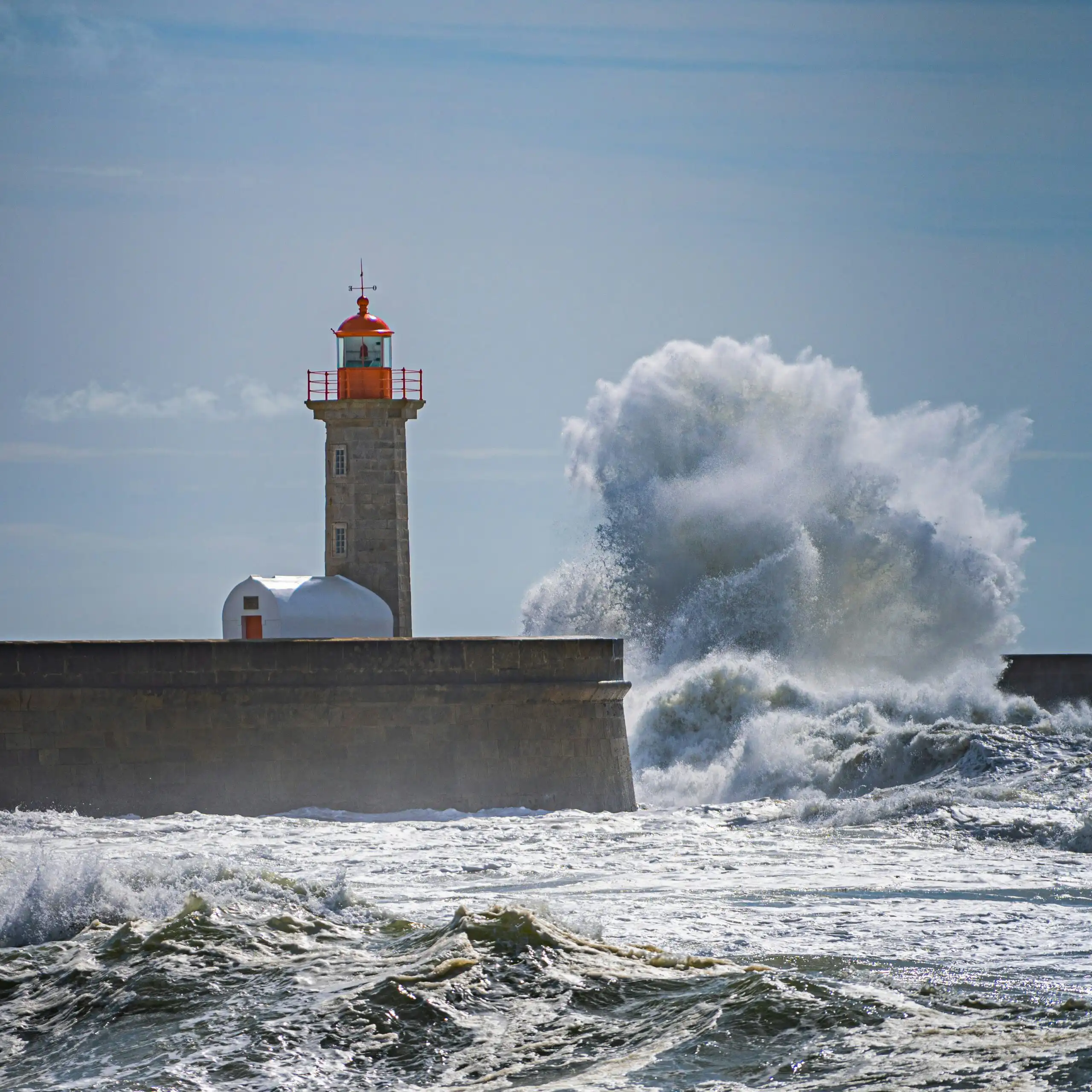 Gegen einen Leuchtturm nschlagen hohe Meereswellen,