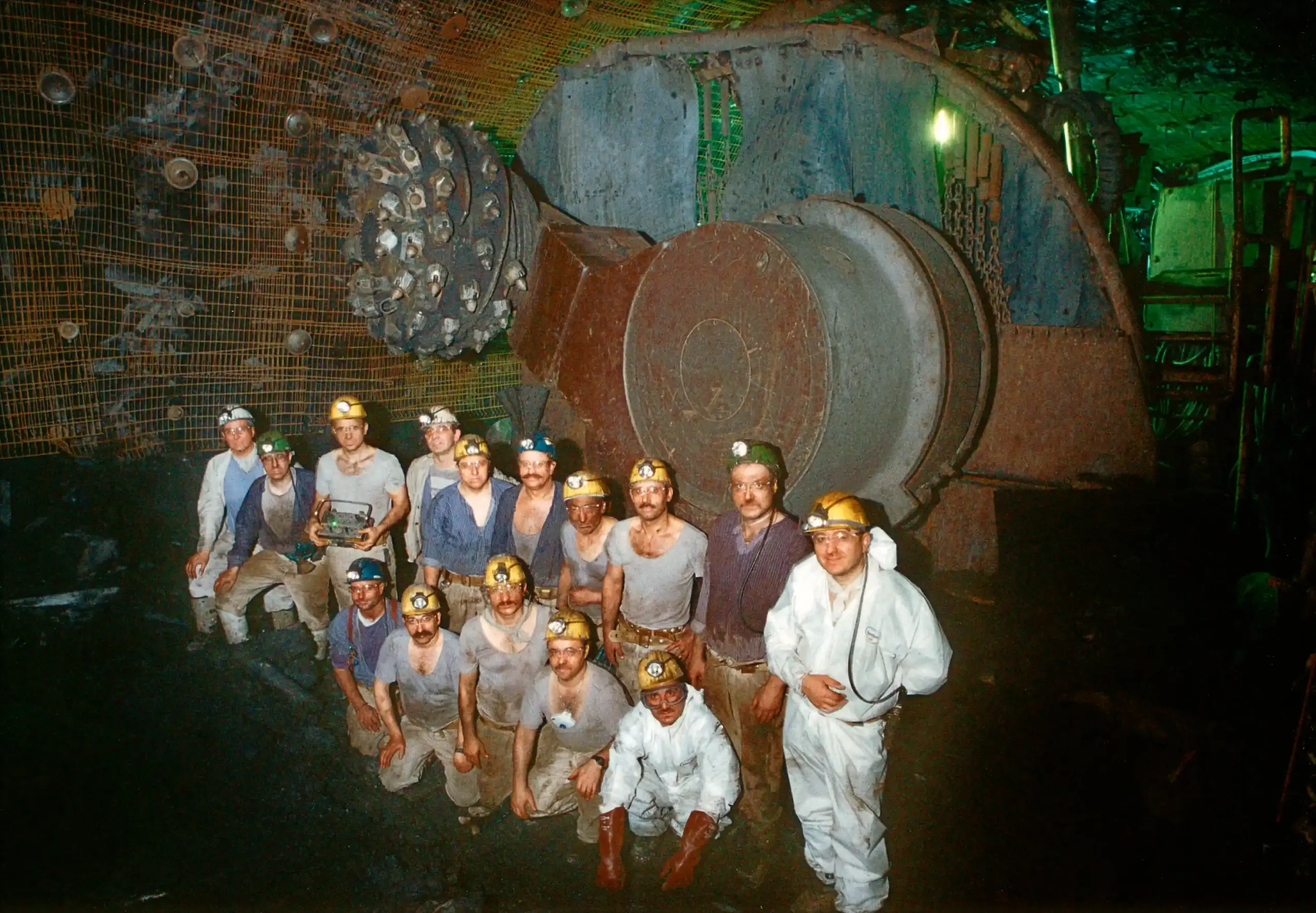 Eine Gruppe Bergmänner steht im Jahr 2000 vor einer Maschine unter Tage.