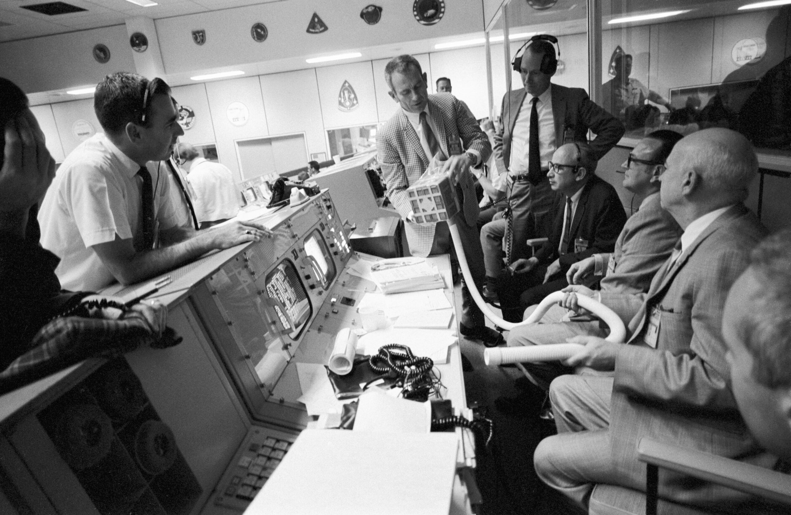 Männer sitzen und stehen in einem Vüro voller Computer in den USA in den 70ern.