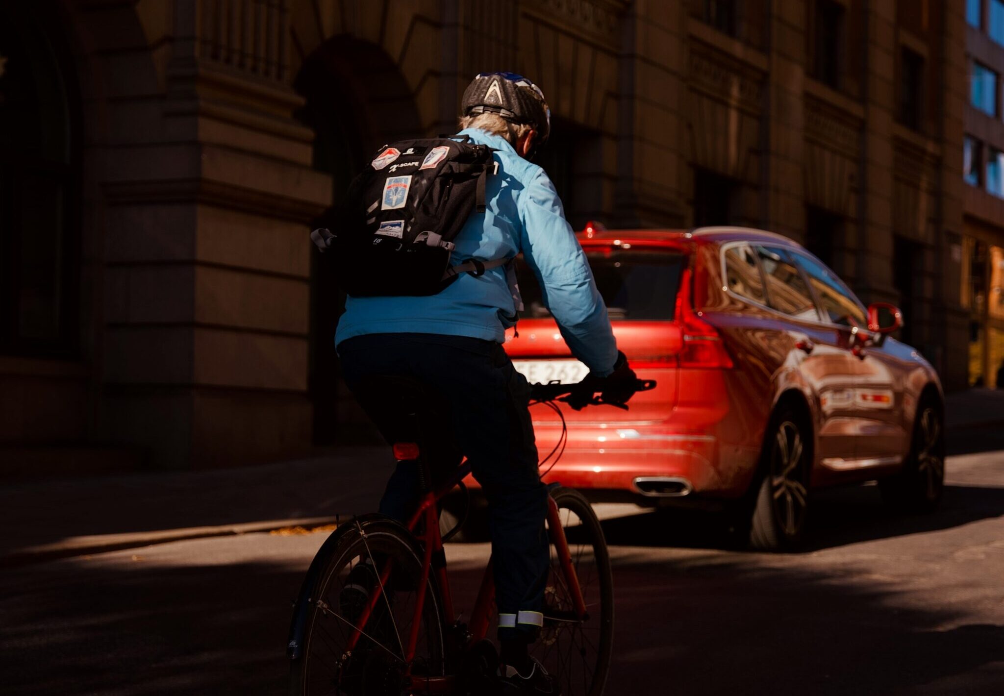 Ein Radfahrer und ein Auto fahren auf einer Stra&szlig;e.
