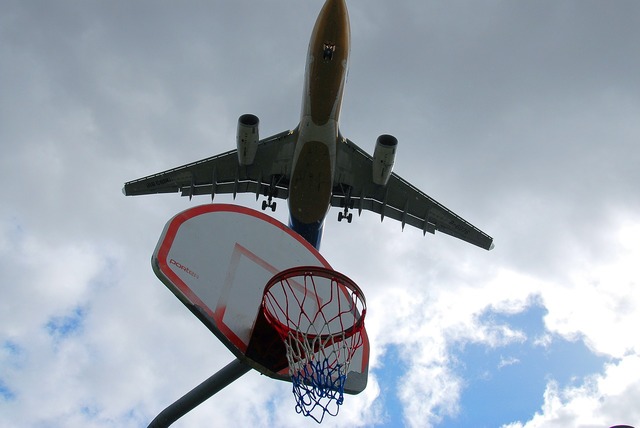 Ein Flugzeug fliegt über einem Basketballkorb entlang.